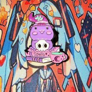 Women’s Accessories Purple Frog Holding Skull Enamel Pin- book, hat, and Teacup
